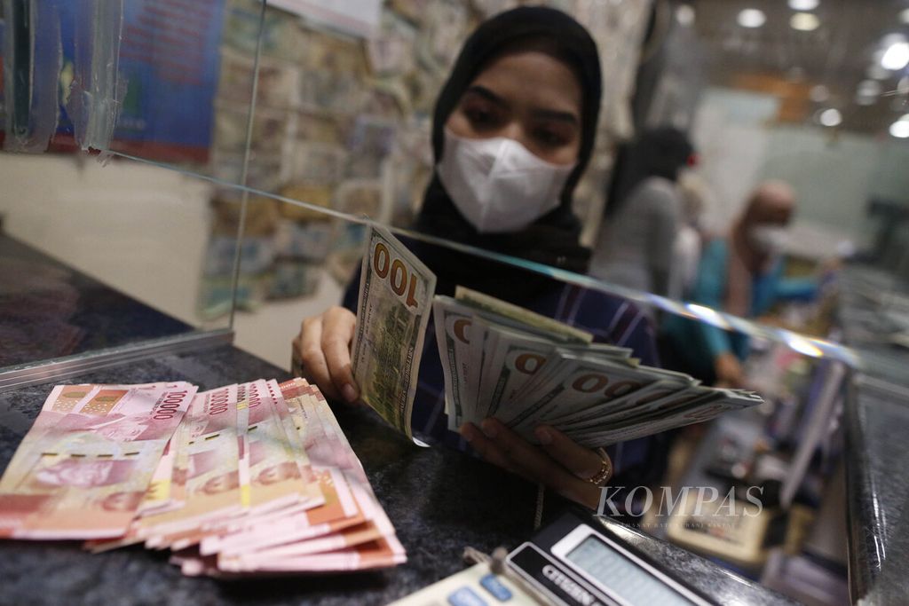 Karyawan menunjukkan uang rupiah dan dollar AS di tempat penukaran valuta asing PT Valuta Artha Mas, ITC Kuningan, Jakarta, Senin (17/10/2022). 