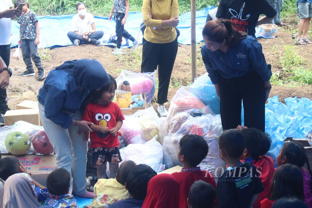 Pembawa acara penyerahan donasi dari Yayasan Dana Kemanusiaan Kompas mengajak anak-anak bermain di Kampung Sedong Kulon, Kelurahan Bojongherang, Kecamatan Cianjur, Kabupaten Cianjur, Jawa Barat, Sabtu (21/1/2023). 