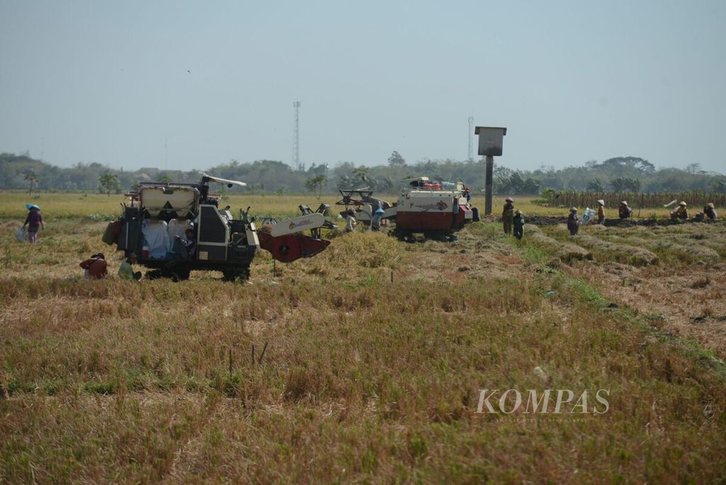 Buruh tani berada di antara mesin pemanen padi di Desa Tosari, Kecamatan Brangsong, Kabupaten Kendal, Jawa Tengah, Selasa (10/9/2019). Mekanisasi alat pertanian modern mulai diterapkan di sejumlah wilayah untuk meningkatkan produktivitas petani. 
