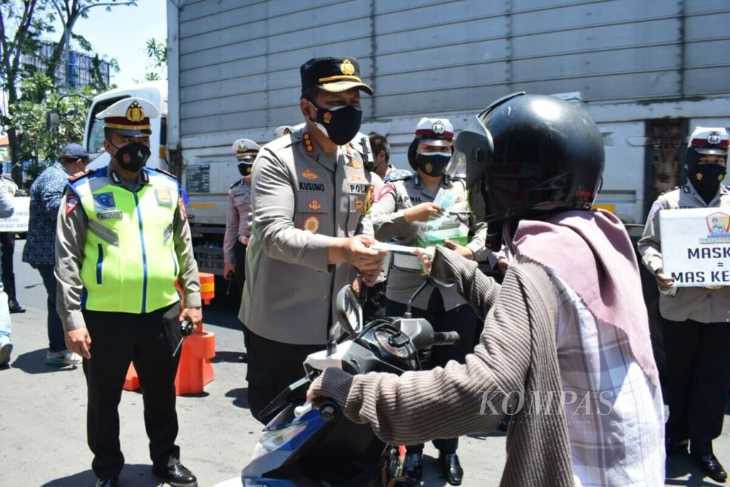 Kepala Kepolisian Resor Kota Sidoarjo Komisaris Besar Kusumo Wahyu Bintoro membagikan masker dalam acara sosialisasi protokol kesehatan kepada pengendara kendaraan bermotor, Senin (20/9/2021), di Sidoarjo, Jawa Timur.