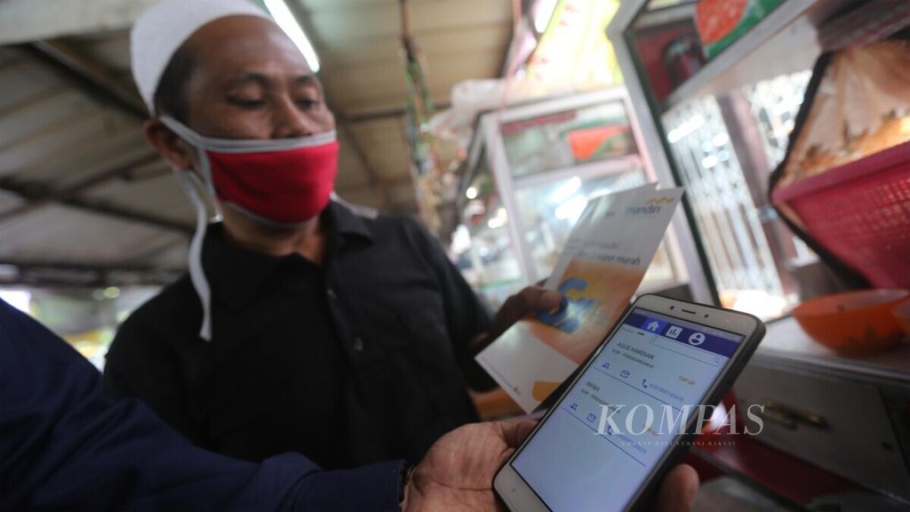 Pedagang kuliner di Pasar Mayestik, Jakarta, sedang mendengarkan penjelasan tenaga pemasar mikro Bank Mandiri tentang aplikasi kredit mikro daring milik Bank Mandiri, Senin (29/6/2020). 