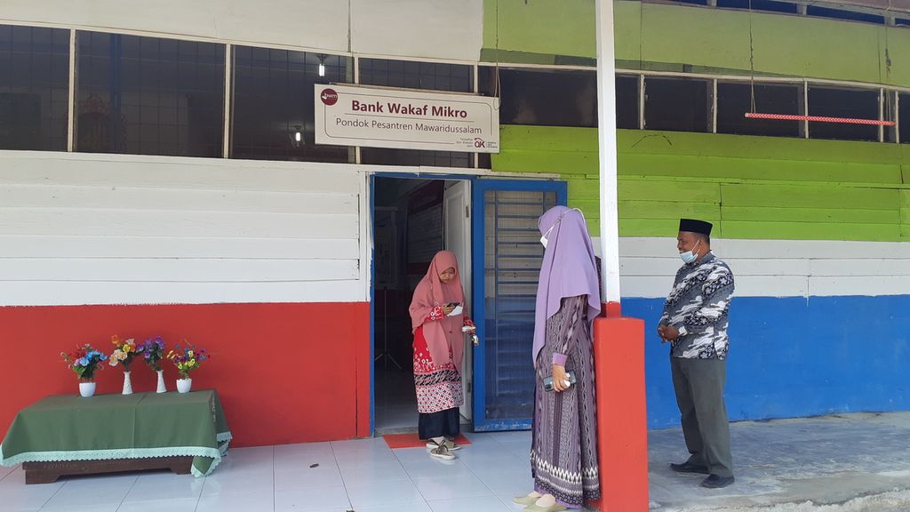 Petugas Bank Wakaf Mikro Pondok Pesantren Mawaridussalam, Kabupaten Deli Serdang, Sumatera Utara, sedang berjaga di depan pintu masuk, Sabtu (26/3/2022). 