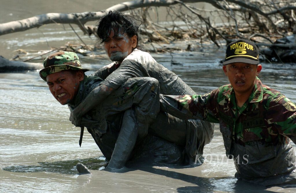 Sambil meringis menahan panasnya lumpur, seorang anggota TNI menggendong warga Desa Siring, Kecamatan Porong, Sidoarjo, Jawa Timur yang terjebak lumpur di rumahnya akibat tanggul tidak dapat menahan luapan lumpur, Kamis (10/8).