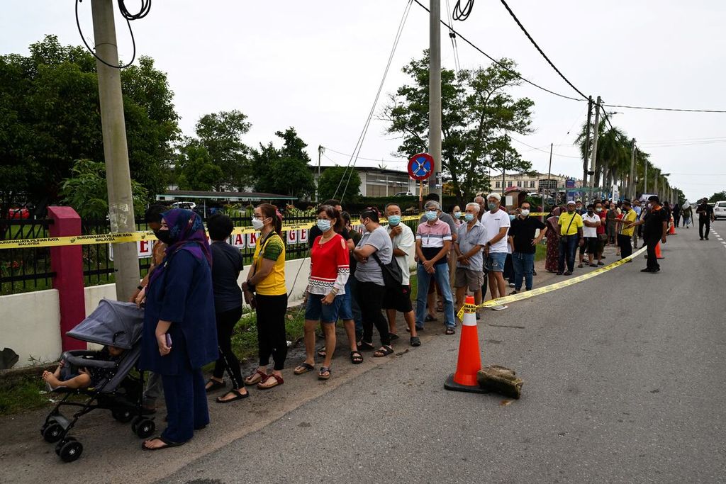 Pemilih Malaysia mengantre di luar tempat pemungutan suara saat pemilu parlemen ke-15 di Bera, Negara Bagian Pahang, 19 November 2022. 