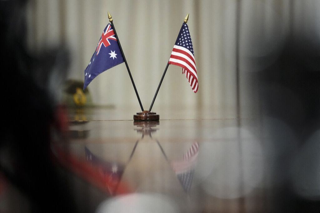 Arsip foto pada 22 September 2021 menunjukkan bendera AS dan Australia dilletakkan di atas meja saat pertemuan antara Perdana Menteri Australia kala itu Scott Morrison dan Menteri Pertahanan AS Lloyd Austin di markas Pentagon di Arlington, Virginia. Sepekan sebelumnya, AS, Australia, dan Inggris menyepakati pembentukan AUKUS. 