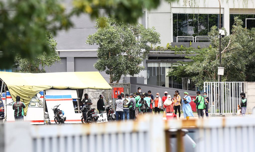Pengemudi ojek daring mengantarkan makanan dan berbagai barang kiriman ke Rumah Sakit Darurat Wisma Atlet, Kemayoran, Jakarta Pusat, Senin (17/1/2022).
