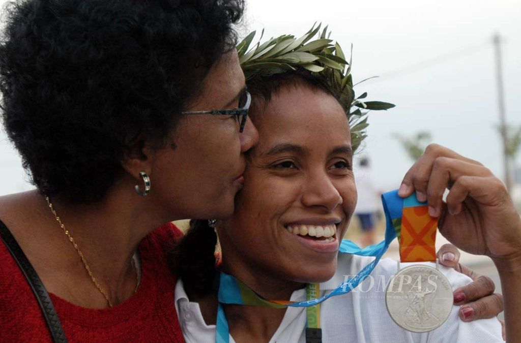 Lisa Rumbewas mendapat ciuman dari ibunya seusai meraih medali perak Olimpiade Athena 2004 nomor angkat besi di kelas 53 kilogram.