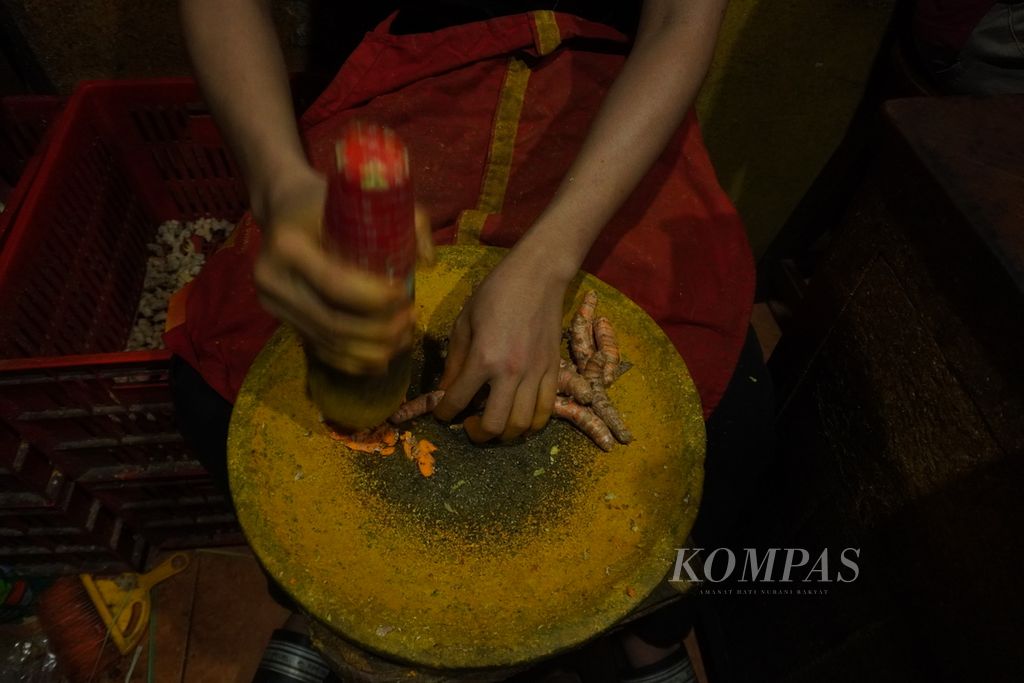 Pemuda menumbuk kunyit di kedai Wedang Jahe Mbah Jo, Kecamatan Semarang Selatan, Kota Semarang, Jawa Tegah, Jumat (31/5/2024). Pekerja di kedai jahe yang berdiri sejak 1996 tersebut merupakan anak-anak muda. Pembeli di kedai jamu yang menjual aneka jamu dengan bahan dasar jahe, kunyit, dan kencur tersebut mayoritas pemuda.