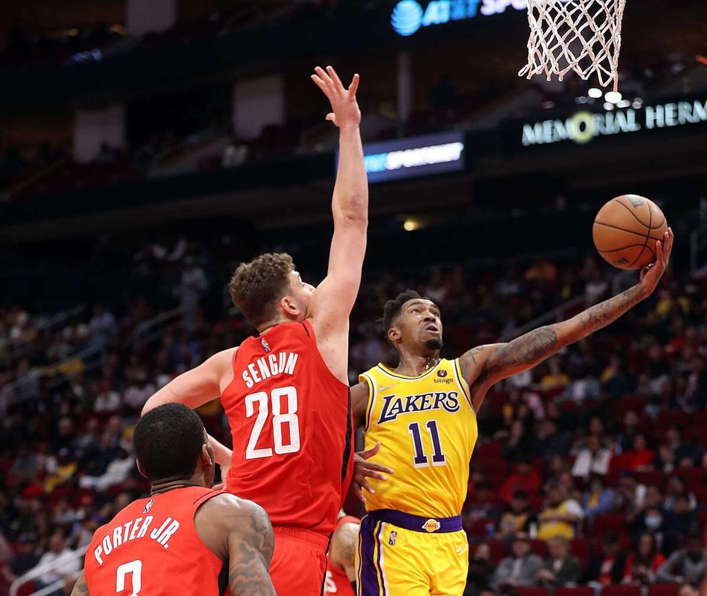 Pemain LA Lakers, Malik Monk (kanan), berupaya memasukkan bola ke ring Houston Rockets pada lanjutan NBA di Toyota Center, Kamis (10/3/2022) WIB. Lakers takluk 130-139 pada laga itu.