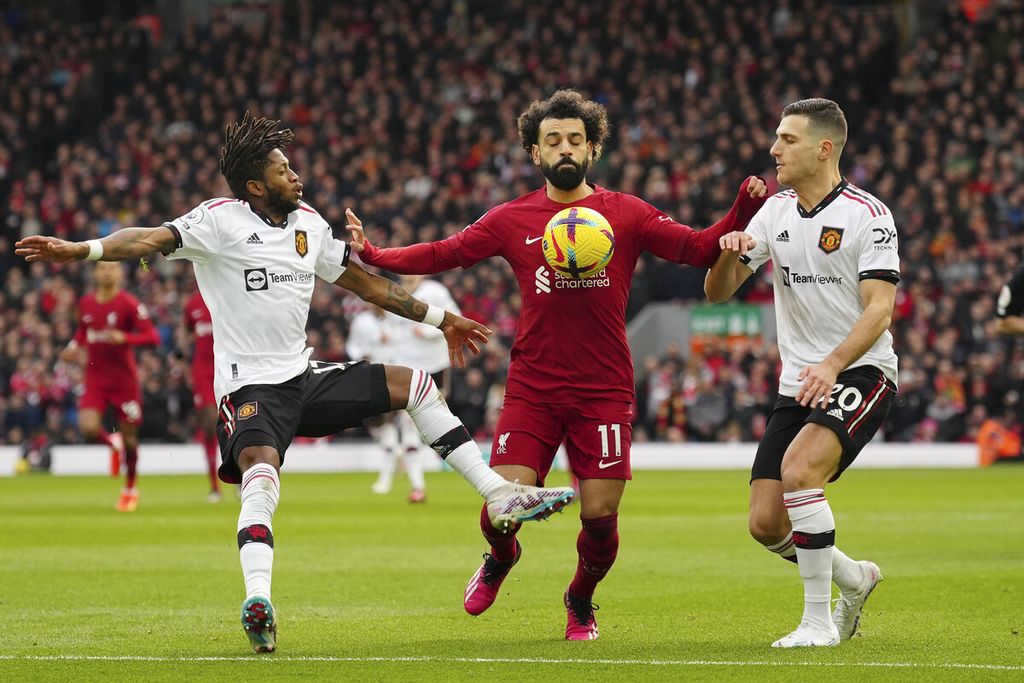 Pemain Liverpool, Mohamed Salah (tengah), coba menahan pemain Manchester United, Diogo Dalot (kanan), dan Fred dalam pertandingan sepak bola Liga Inggris antara Liverpool dan Manchester United di Anfield di Liverpool, Inggris, Minggu, 5 Maret 2023.