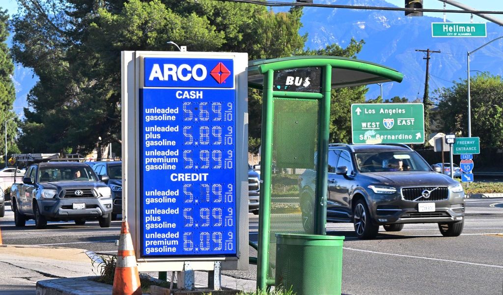 Para komuter dengan kendaraan melewati papan reklame yang memajang harga bahan bakar di sebuah stasiun pengisian bakar bakar umum (SPBU) di Alhambra, California, AS, 19 Oktober 2022. Data Pemerintah AS menunjukkan, tingkat inflasi di AS mulai menurun pada Oktober 2022. 