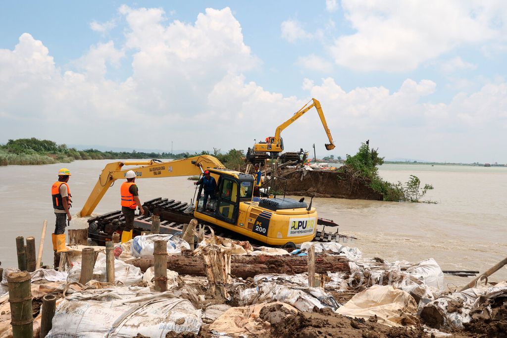 Petugas menggunakan alat berat untuk memperbaiki tanggul Sungai Wulan yang jebol sepanjang 35 meter hingga menyebabkan banjir beberapa hari lalu, di Kecamatan Karanganyar, Kabupaten Demak, Jawa Tengah, Senin (12/2/2024). 