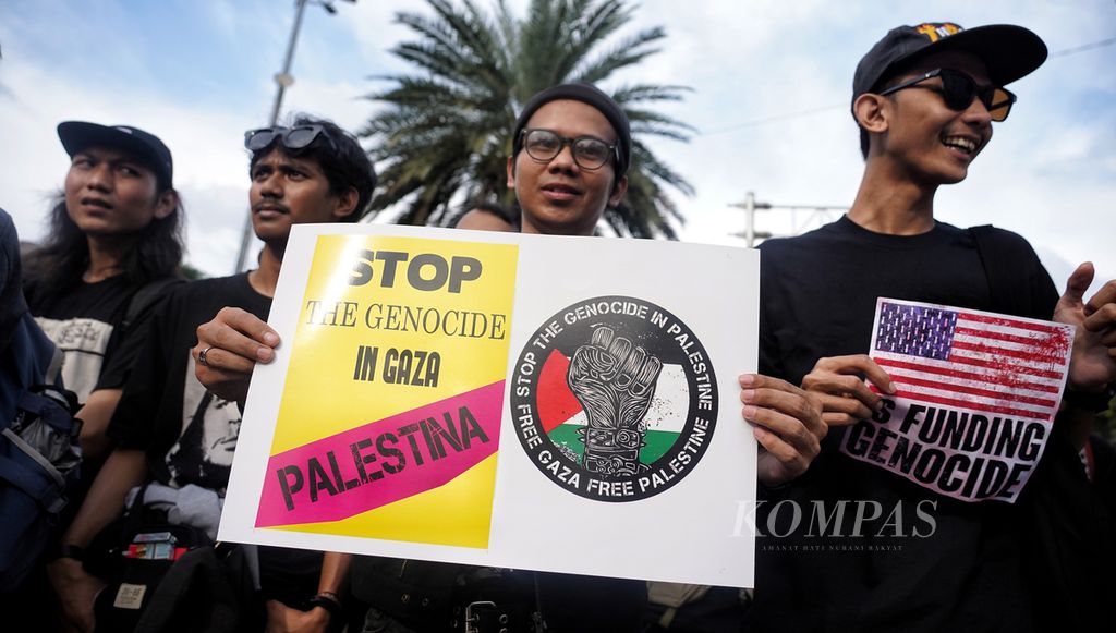 Poster carried by participants of the Stop Palestine Genocide action in front of the United States Embassy, ​​Jakarta, Friday (19/4/2024).