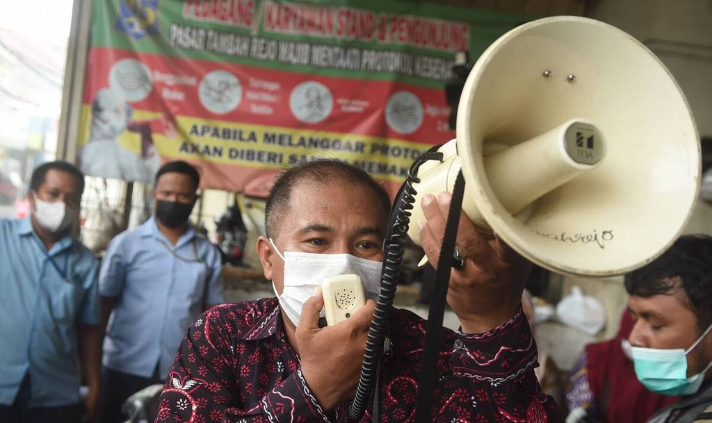 Petugas mengajak warga yang antre untuk tertib saat operasi pasar minyak goreng curah untuk pedagang di Pasar Tambahrejo, Kota Surabaya, Jawa Timur, Jumat (18/2/2022).