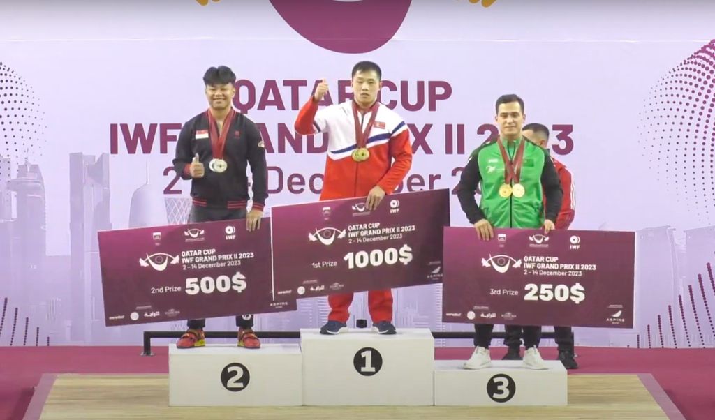 Lifter Indonesia, Rahmat Erwin Abdullah (kiri), memborong tiga medali perak kelas 81 kilogram putra di IWF Grand Prix II, di Doha, Qatar, Sabtu (9/12/2023) malam.