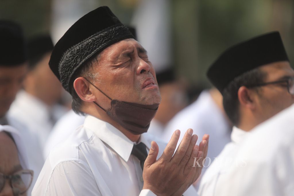 Guru honorer menengadahkan tangan saat doa dalam upacara pelantikan di halaman Balai Kota DKI Jakarta, Gambir, Jakarta Pusat, Jumat (28/7/2023). 