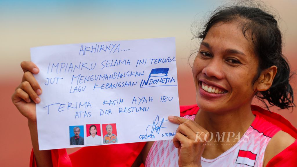 Pelari Indonesia, Odekta Elvina Naibaho, menunjukkan catatan rasa bersyukurnya seusai masuk finis di urutan pertama pada nomor lari maraton putri SEA Games Vietnam 2021 di Stadion My Dinh, Hanoi, Vietnam, Kamis (19/5/2022). Ia meraih emas.
