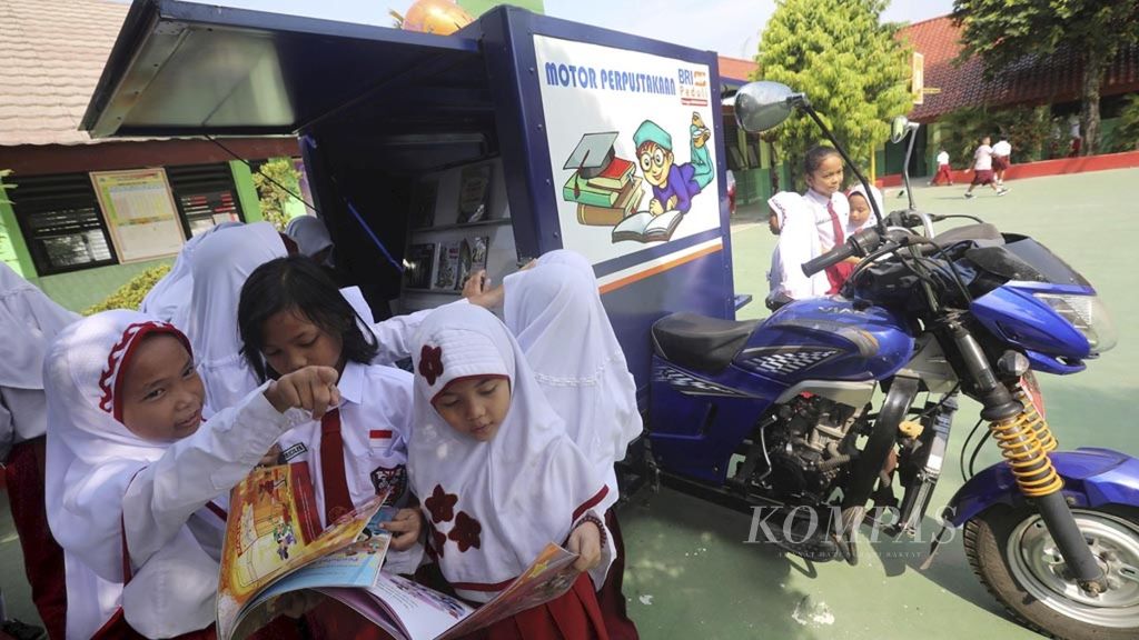 Perpustakaan KelilingSiswa membaca buku-buku yang tersedia di motor perpustakaan keliling di SDN 02 Malakasari, Jakarta Timur, Selasa (8/1/2019). Layanan perpustakaan keliling ini menjadi sarana yang dinanti para siswa untuk membaca buku-buku baru dan menambah pengetahuan.