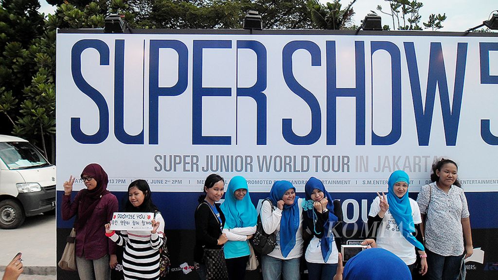 Ilustrasi. Penggemar boyband Korea, Super Junior, berfoto di depan papan konser "Supershow 5" di Mata Elang International Stadium, Ancol, Jakarta Utara, Minggu 2 Juni 2013.