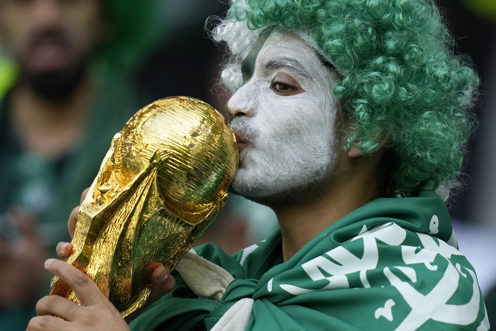 Fans Arab Saudi mencium replika Piala Dunia saat menyaksikan laga kontra Polandia di penyisihan Grup C Piala Dunia Qatar di Stadion Education City, ibu kota Doha, Sabtu (26/11/2022). Arab Saudi kalah 0-2 dari Polandia meski sebelumnya menang 2-1 atas Argentina.
