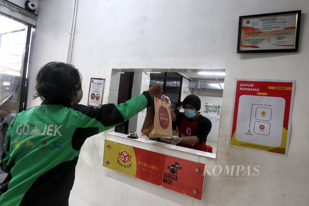 Pengemudi Gojek tiba di Dapur Bersama GoFood Bintaro, Jakarta Selatan, untuk mengambil pesanan makanan, Minggu (20/9/2020). Dapur bersama tersebut dibuat untuk memfasilitasi UMKM kuliner agar lebih cepat berkembang.