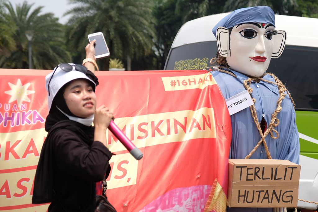 Salah satu massa aksi membacakan puisi di kawasan Patung Kuda Arjuna Wiwaha, Jakarta Pusat, Minggu (27/11/2022). Puluhan massa aksi yang tergabung ke dalam organisasi Perempuan Mahardhika melakukan aksi untuk memperingati 16 hari anti kekerasan terhadap perempuan. 