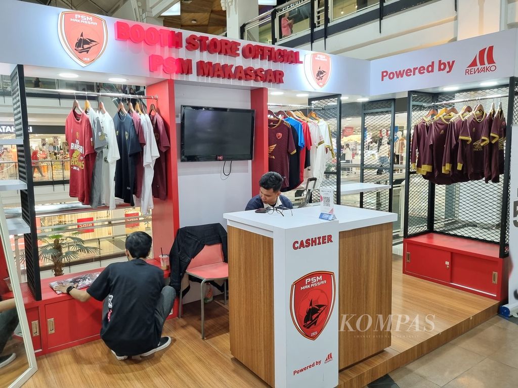 Dua orang pelayan merapikan kaos dan jersei di gerai cendera mata PSM Makassar di salah satu mall di Kota Makassar, Sulawesi Selatan, Sabtu (24/6/2023). Penjualan jersei PSM meningkat pesat di tahun ini berkat prestasi meraih gelar juara Liga 1 2022-2023.