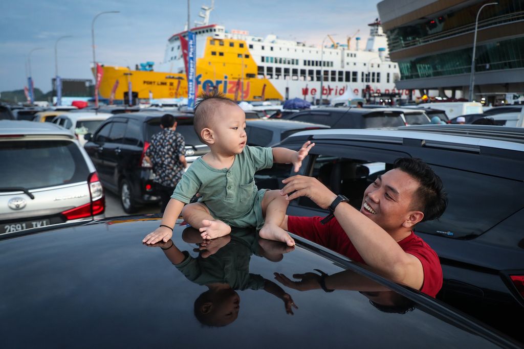 A father invites his son to play while waiting in line to enter the ferry at Bakauheni Harbor, Lampung, Tuesday (25/4/2023). Based on data from the Bakauheni Command Post for the period 24 to 25 April 2023 at 08.00, a total of 88,758 people had crossed from Bakauheni Port in Lampung to Merak Port in Banten.