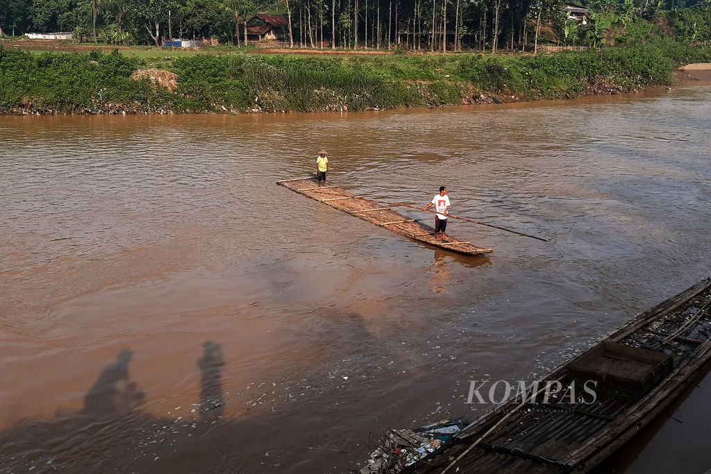 Warga yang menyewakan jasa penyeberangan Sungai Cisadane di Desa Pabuaran, Kecamatan Gunung Sindur, Kabupaten Bogor, Minggu (20/6/2020). 