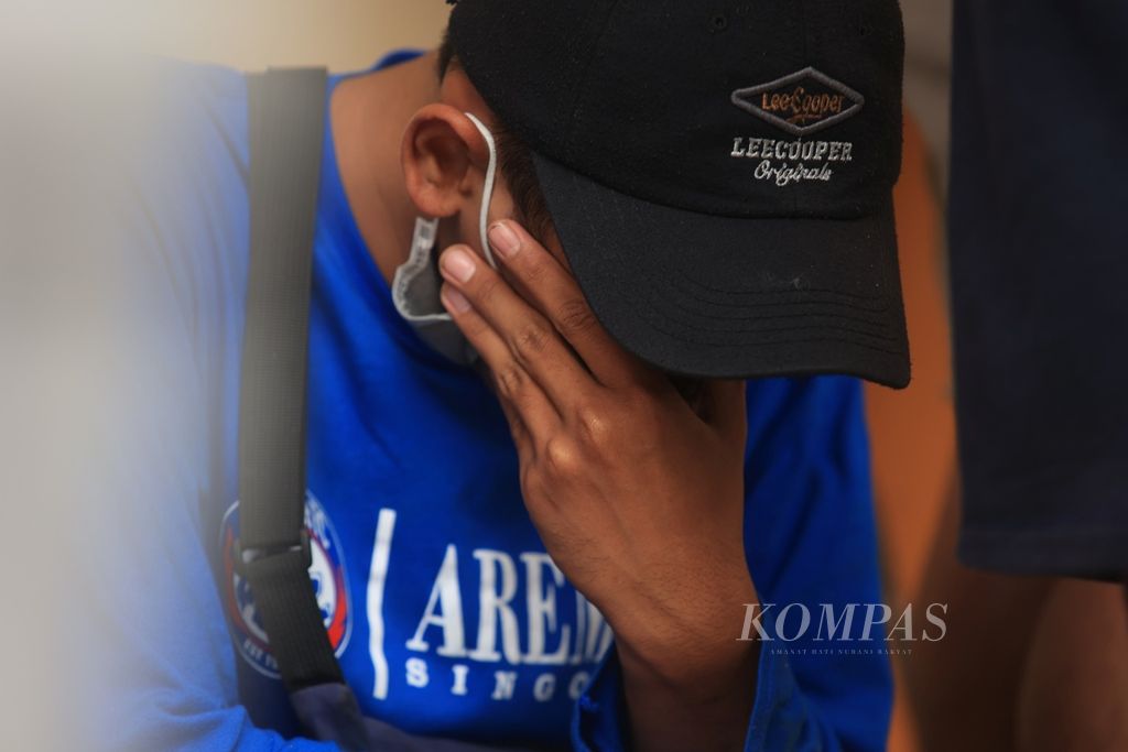 Keluarga korban kerusuhan di Stadion Kanjuruhan menunggu proses identifikasi jenazah di Instalasi Kedokteran Forensik Medikolegal Rumah Sakit Saiful Anwar, Malang, Jawa Timur, Minggu (2/10/2022). 