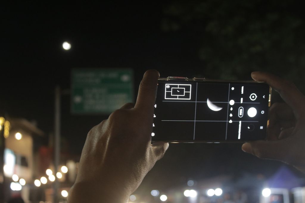 Salah satu warga mengamati proses gerhana bulan total melalui ponsel genggamnya di Jalan Teuku Umar, Kota Bandung, Jawa Barat, Rabu (26/5/2021).