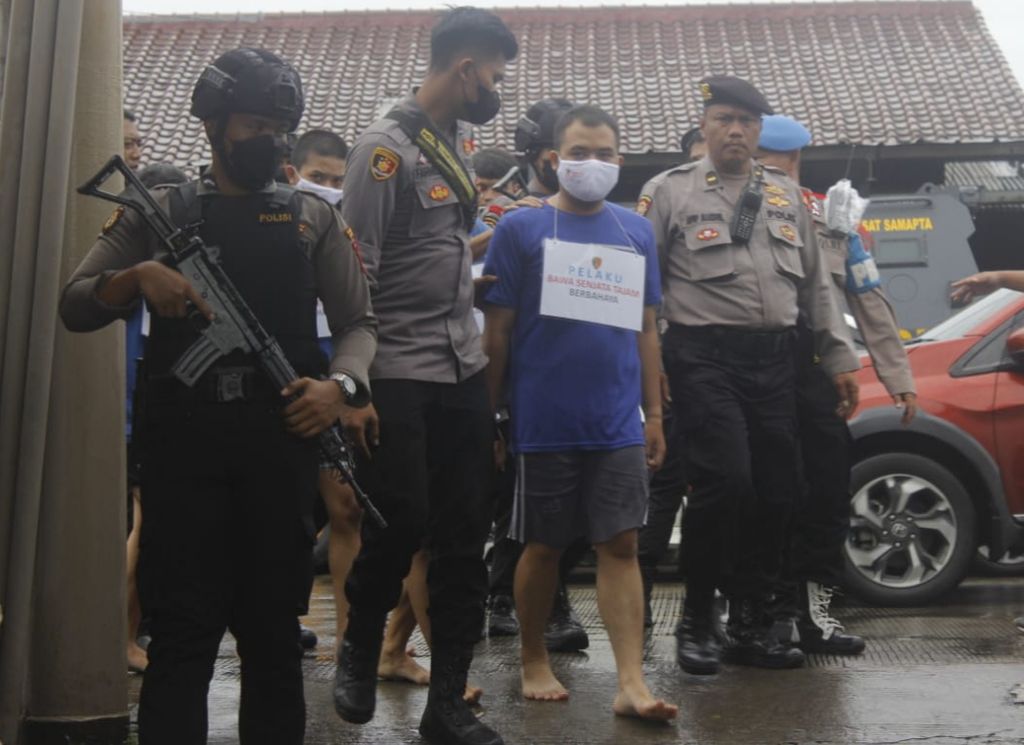 Polisi Polresta Bogor menggiring pelaku yang mengancam warga dengan senjata tajam di Gang Muha, Kelurahan Menteng, Kota Bogor, Jawa Barat, Jumat (29/12/2022).