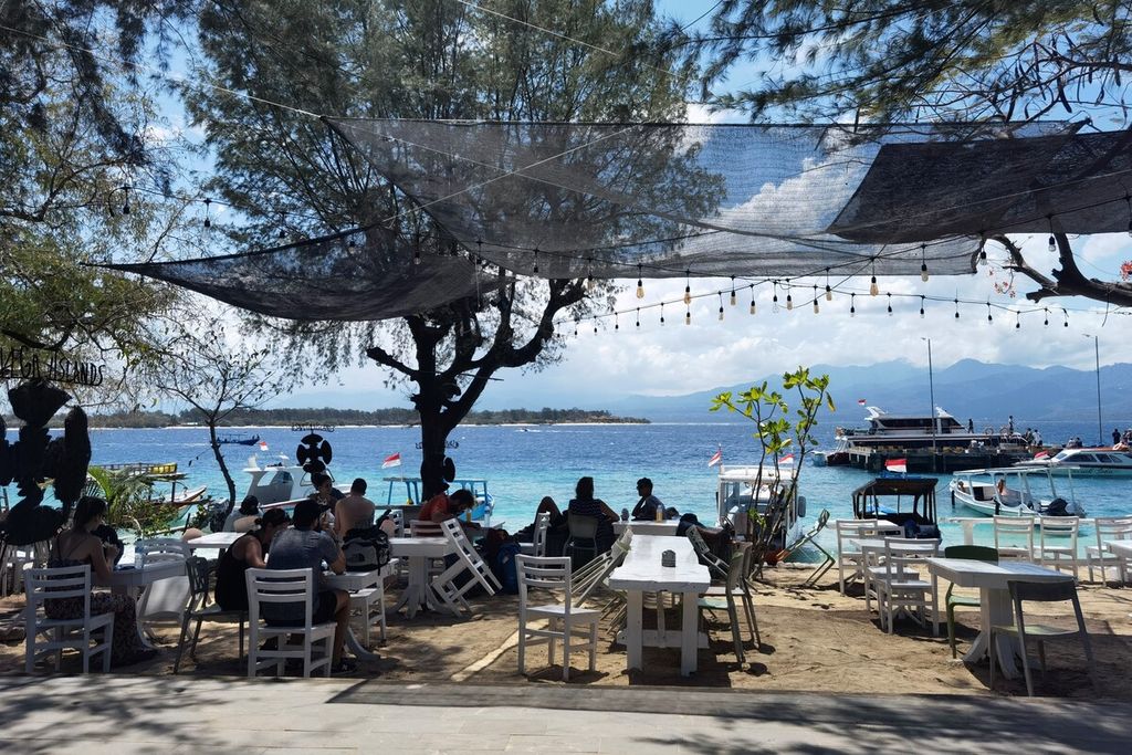 Wisatawan menikmati makan siang di salah satu restoran tepi pantai di Gili Trawangan, Desa Gili Indah, Kecamatan Pemenang, Kabupaten Lombok Utara, Nusa Tenggara Barat, Selasa (11/10/2022).