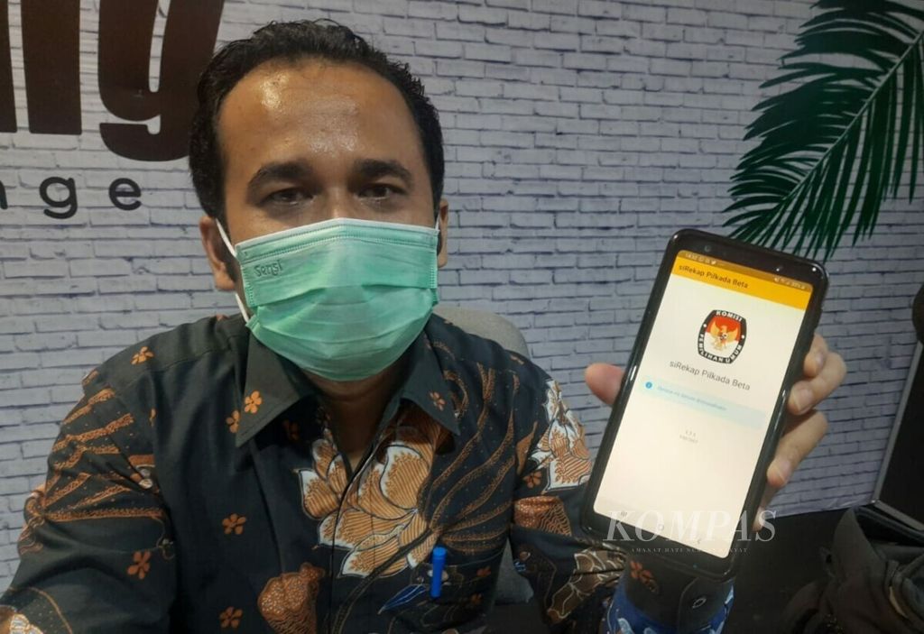 Anggota KPU Sumatera Barat Divisi Teknis Penyelenggaraan, Gebril Daulay, menunjukkan tampilan depan aplikasi Sirekap <i>mobile</i> di ponselnya di Padang, Sumatera Barat, Rabu (2/12/2020). 