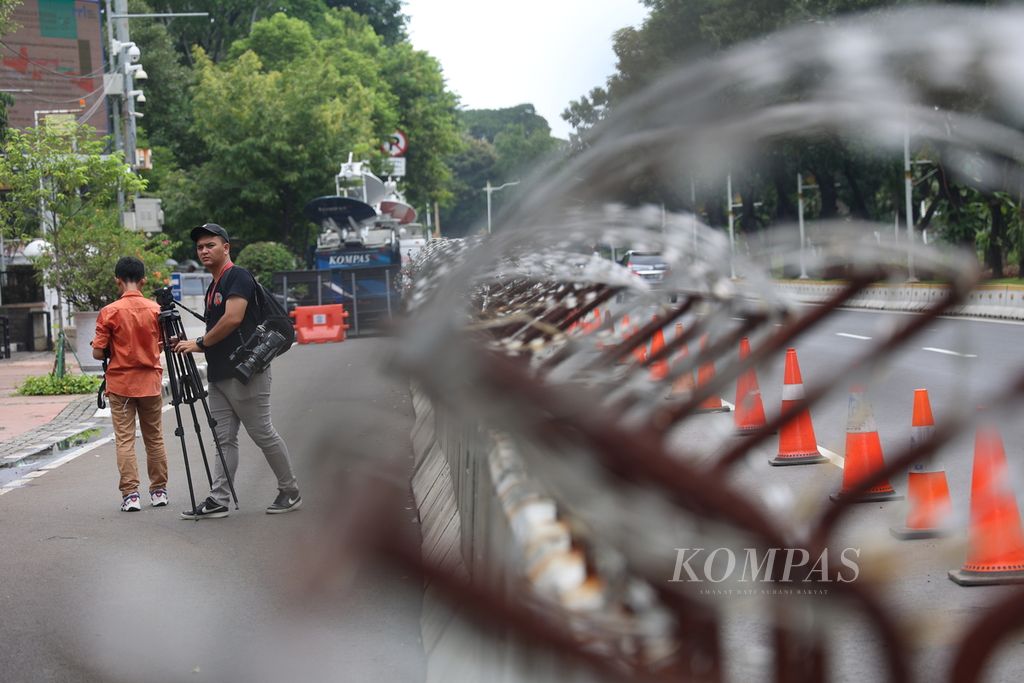 Jurnalis televisi seusai siaran langsung di depan Gedung Mahkamah Konstitusi (MK), Jakarta, Minggu (21/4/2024). Menjelang pembacaan putusan perselisihan hasil pemilihan umum Pilpres 2024 pada Senin (22/4/2024), penjagaan di sekitar Gedung MK diperketat. 