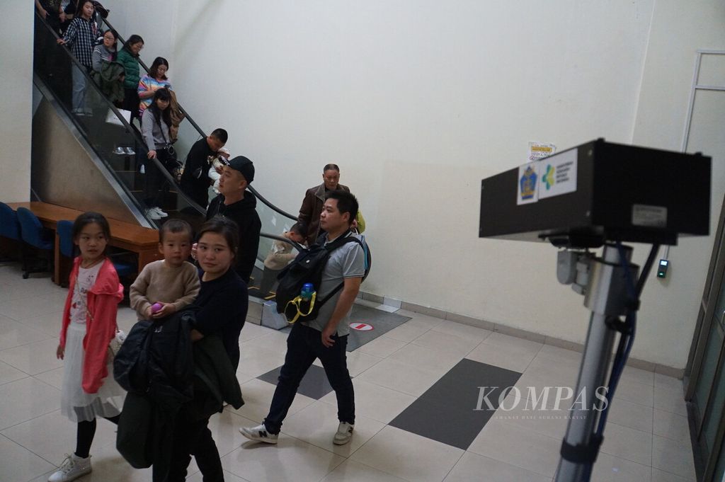 Penumpang pesawat Lion Air JT 2742 dari Changsha, China, diperiksa suhu tubuhnya dengan alat pemindai suhu tubuh (<i>thermal scanner</i>) ketika berjalan ke pengecekan imigrasi sesaat setelah tiba di Bandara Sam Ratulangi, Manado, Sulawesi Utara, Selasa (21/1/2020). Pesawat itu mengangkut 208 wisatawan asal China.