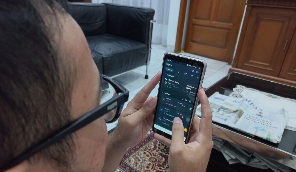 Investor memantau pergerakan harga aset kripto dari aplikasi yang terpasang di ponselnya, di Jakarta, beberapa waktu lalu.
