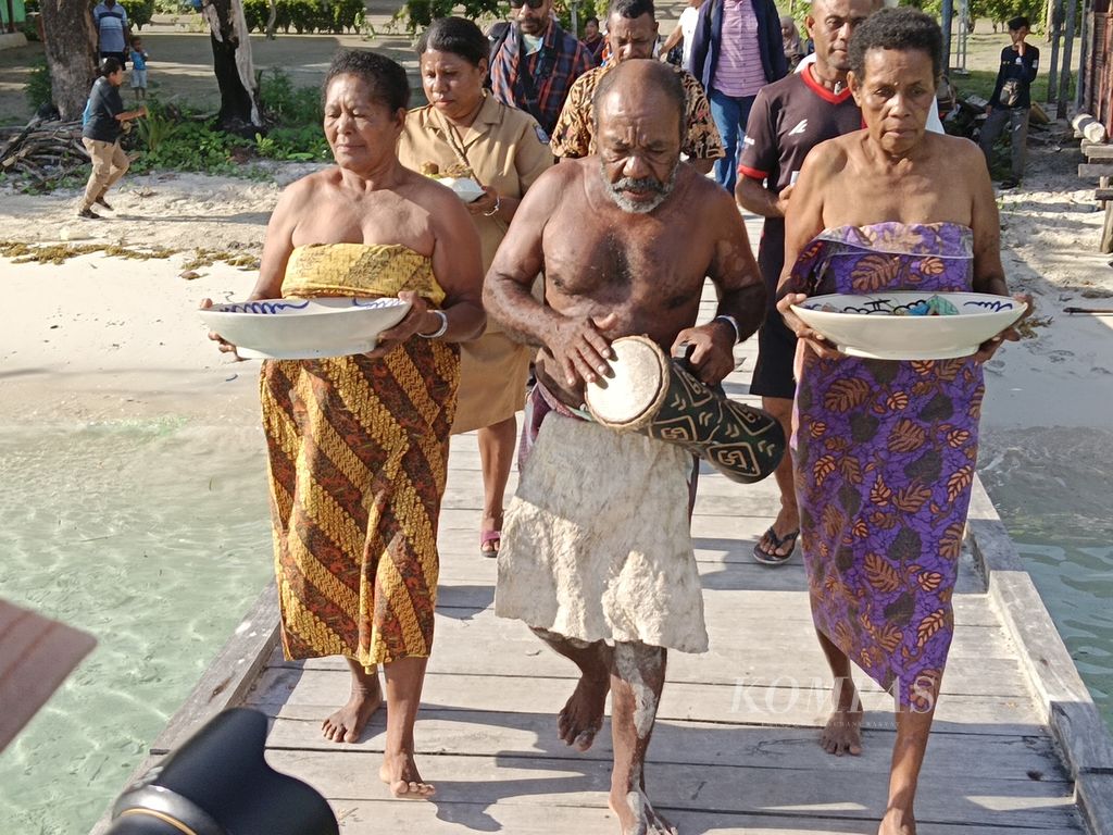 Prosesi upacara adat di Kampung Friwen, Kabupaten Raja Ampat, Papua Barat Daya, Jumat (7/6/2024). Kegiatan ini menjelang pemasangan dua <i>mooring </i>atau alat tambat kapal untuk berlabuh di kawasan konservasi perairan Pulau Friwen dan Pulau Mioskun di Raja Ampat.