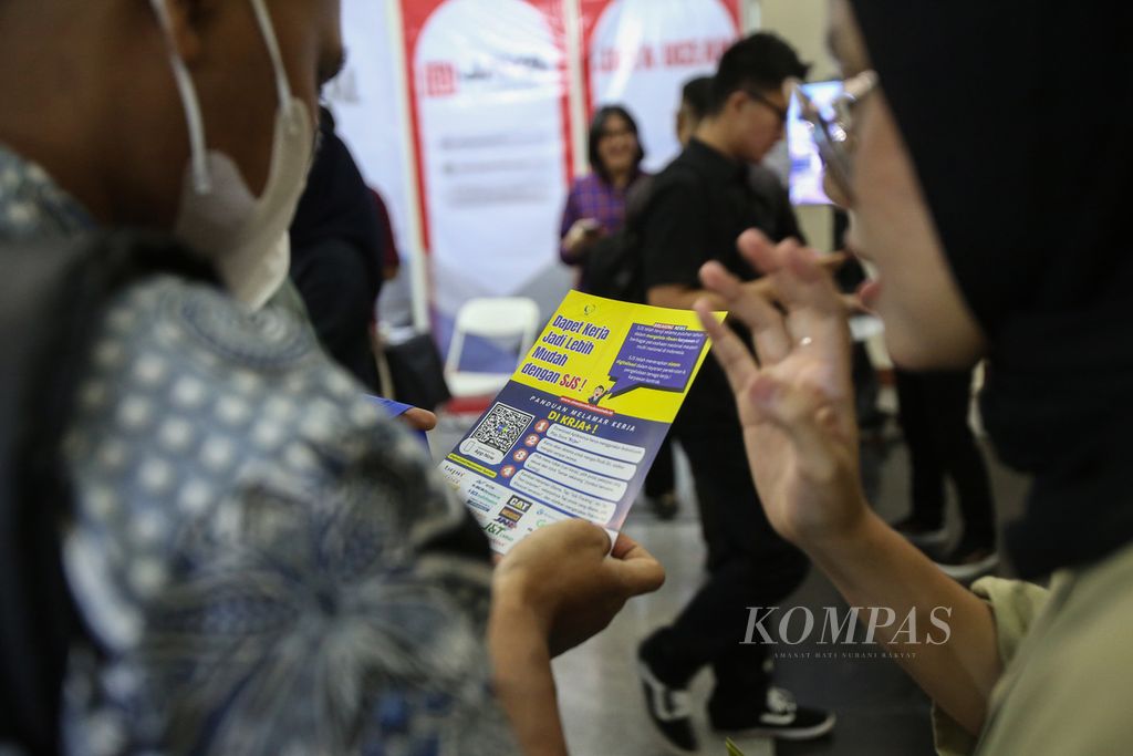 Penjaga stan menjelaskan salah satu lowongan pekerjaan kepada pencari kerja di Indonesia Career Expo Jakarta di Gedung Smesco, Jakarta, Jumat (7/6/2024).