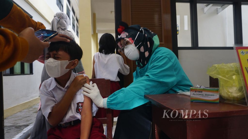Seorang anak saat mengikuti vaksinasi Covid-19 di SD Negeri Kleco 1, Kota Surakarta, Jawa Tengah, Selasa (21/12/2021). Vaksinasi Covid-19 terhadap anak berusia 6-11 tahun di Kota Surakarta baru diselenggarakan perdana pada hari tersebut.