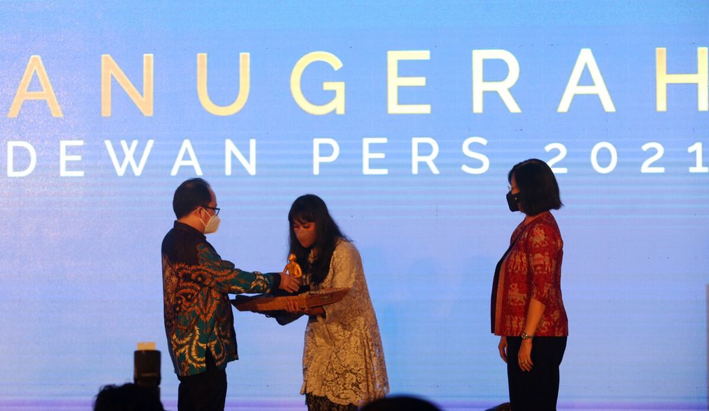Pemimpin Redaksi Harian <i>Kompas</i> Sutta Dharmasaputra (kiri) menerima Anugerah Dewan Pers 2021 kategori media siber untuk Kompas.id dalam ajang Anugerah Dewan Pers 2021 di Jakarta, Desember 2021. 