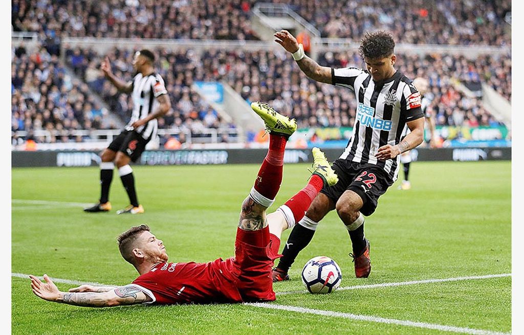 Bek  kiri Liverpool, Alberto Moreno, berebut bola dengan bek kanan Newcastle United, DeAndre Yedlin, pada laga Liga Inggris, Minggu (1/10). Pertandingan ini berakhir imbang 1-1.