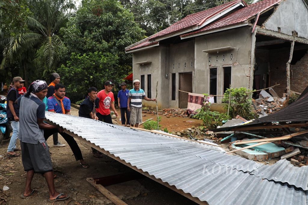 Warga dibantu para relawan menyingkirkan puing-puing bangunan yang roboh karena gempa di Nagari Kajai, Kecamatan Talamau, Kabupaten Pasaman Barat, Sumatera Barat, Senin (28/2/2022). 
