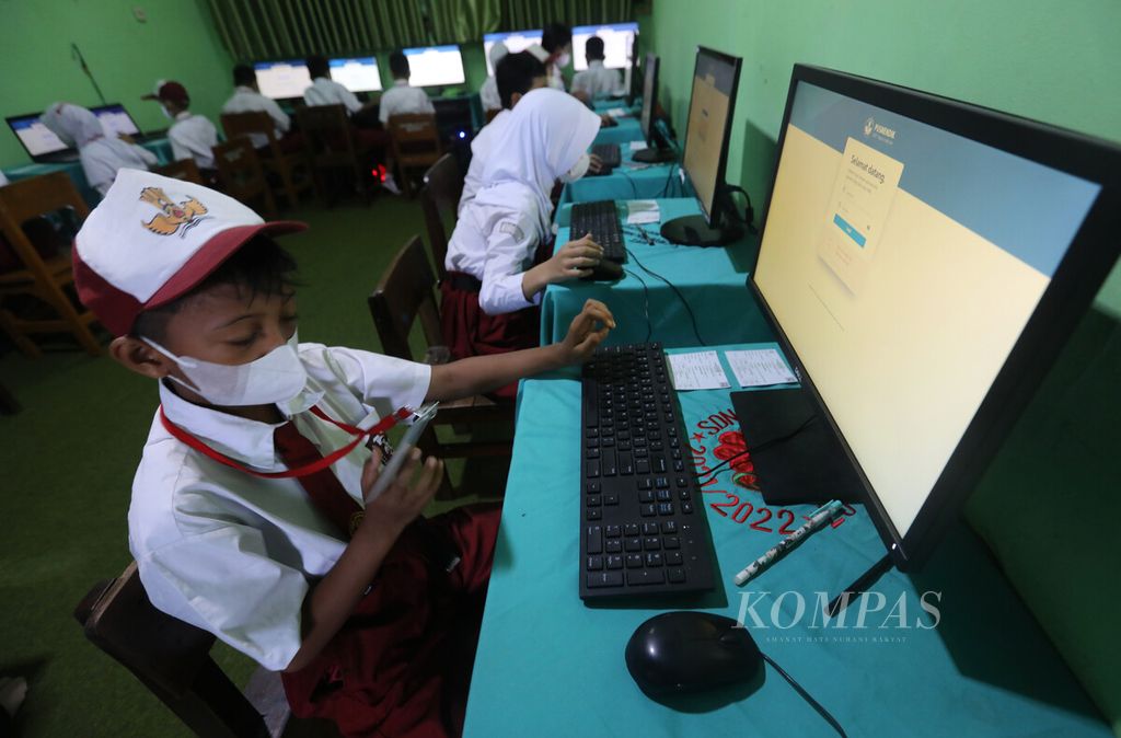 Siswa SDN 07 Pondok Kelapa, Jakarta Timur, melihat kode peserta pada kartu pengenal saat mengikuti Asesmen Nasional Berbasis Komputer (ANBK) di sekolahnya, Senin (24/10/2022). Program evaluasi ANBK diselenggarakan oleh Kemendikbudristek untuk meningkatkan mutu pendidikan dengan memotret <i>input</i>, proses dan <i>output</i> pembelajaran di seluruh satuan pendidikan. Siswa SD yang mengikuti ANBK yakni peserta didik kelas 5 yang dipilih secara acak sebagai sampel.