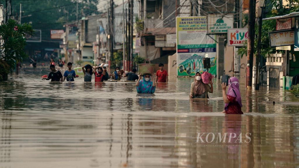 Warga menembus banjir luapan Sungai Bekasi yang merendam ratusan hunian warga di perumahan Pondok Gede Permai di Jatiasih, Kota Bekasi, Jawa Barat, Kamis (17/2/2022). 