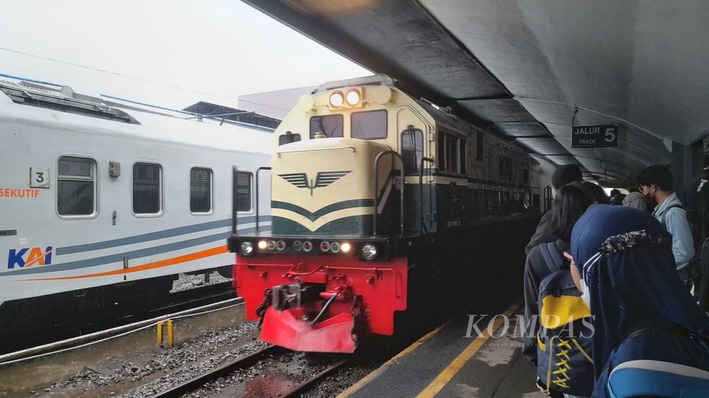 KA Tawangalun tujuan Malang-Banyuwangi dengan lokomotif bercorak klasik melaju dari Stasiun Malang Kota Lama ke Stasiun Malang yang ramai oleh penumpang pada H-6 Lebaran, Minggu (16/4/2023) sore.