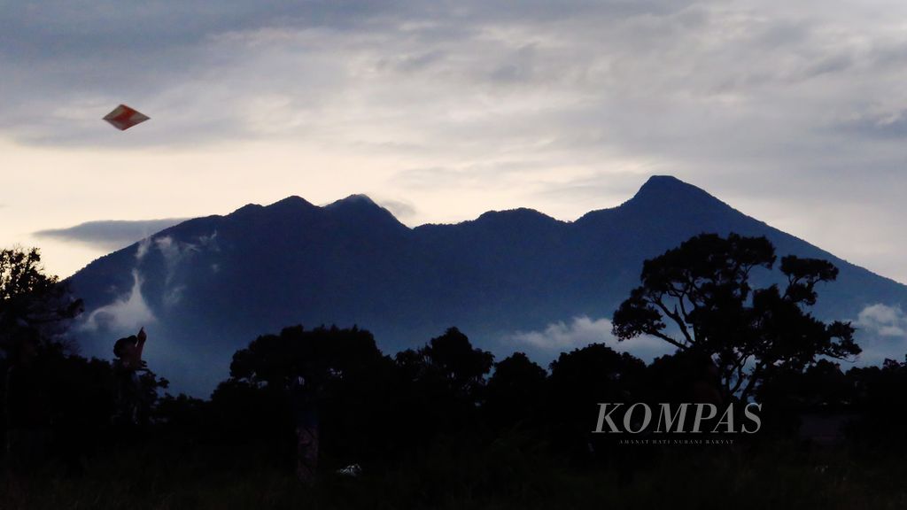 Panorama Gunung Salak menjadi latar saat sejumlah remaja bermain layang-layang di sebuah lahan yang dijadikan kawasan permukiman baru di tepi Jalan Kolonel Ahmad Syam, Kota Bogor, Jawa Barat, Rabu (23/12/2020). 