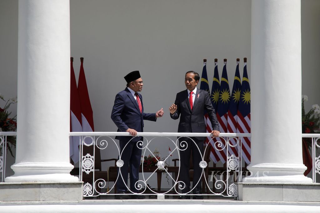 Presiden Joko Widodo berbincang dengan Perdana Menteri Malaysia Anwar Ibrahim berjalan bersama dalam upacara penyambutan di Istana Kepresidenan, Bogor, Jawa Barat, Senin (09/01/2023). Mereka antara lain membahas cara bersama menghadapi diskriminasi minyak sawit oleh sejumlah negara.