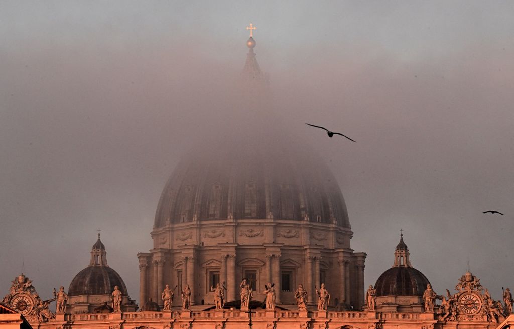 Kabut tipis menutupi Basilikia Santo Petrus di Vatican City, Vatikan, Minggu (1/1/2023).  
