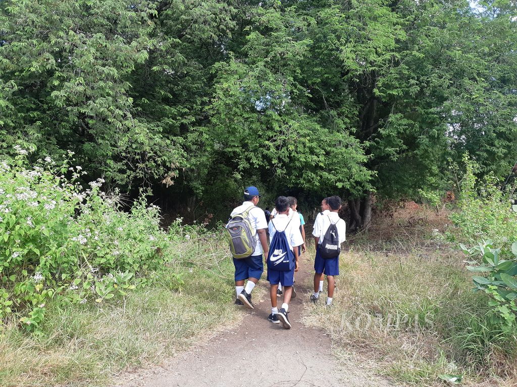 Para murid berjalan kaki seusai pulang dari sekolah di Ilwaki, Pulau Wetar, Kabupaten Maluku Barat Data, Maluku, 9 Agustus 2022. Fasilitas pendidikan di daerah perbatasan itu sangat minim.